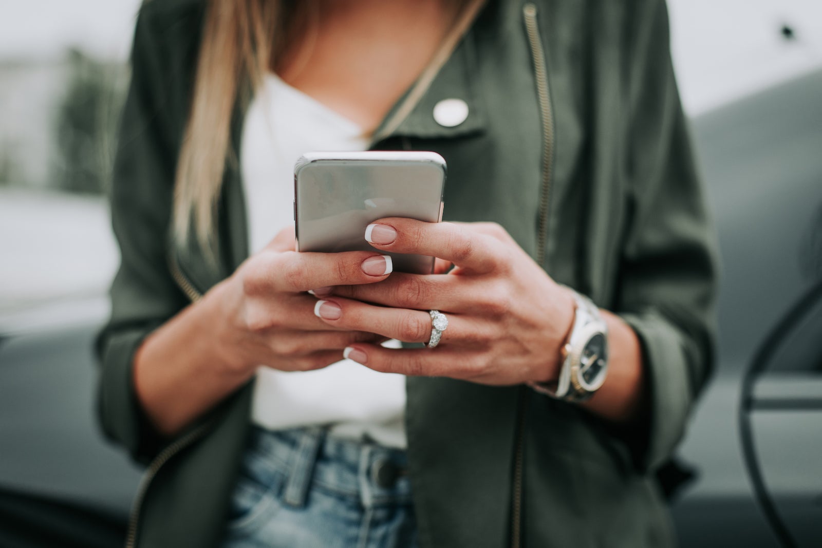 Woman hand typing in the mobile outside