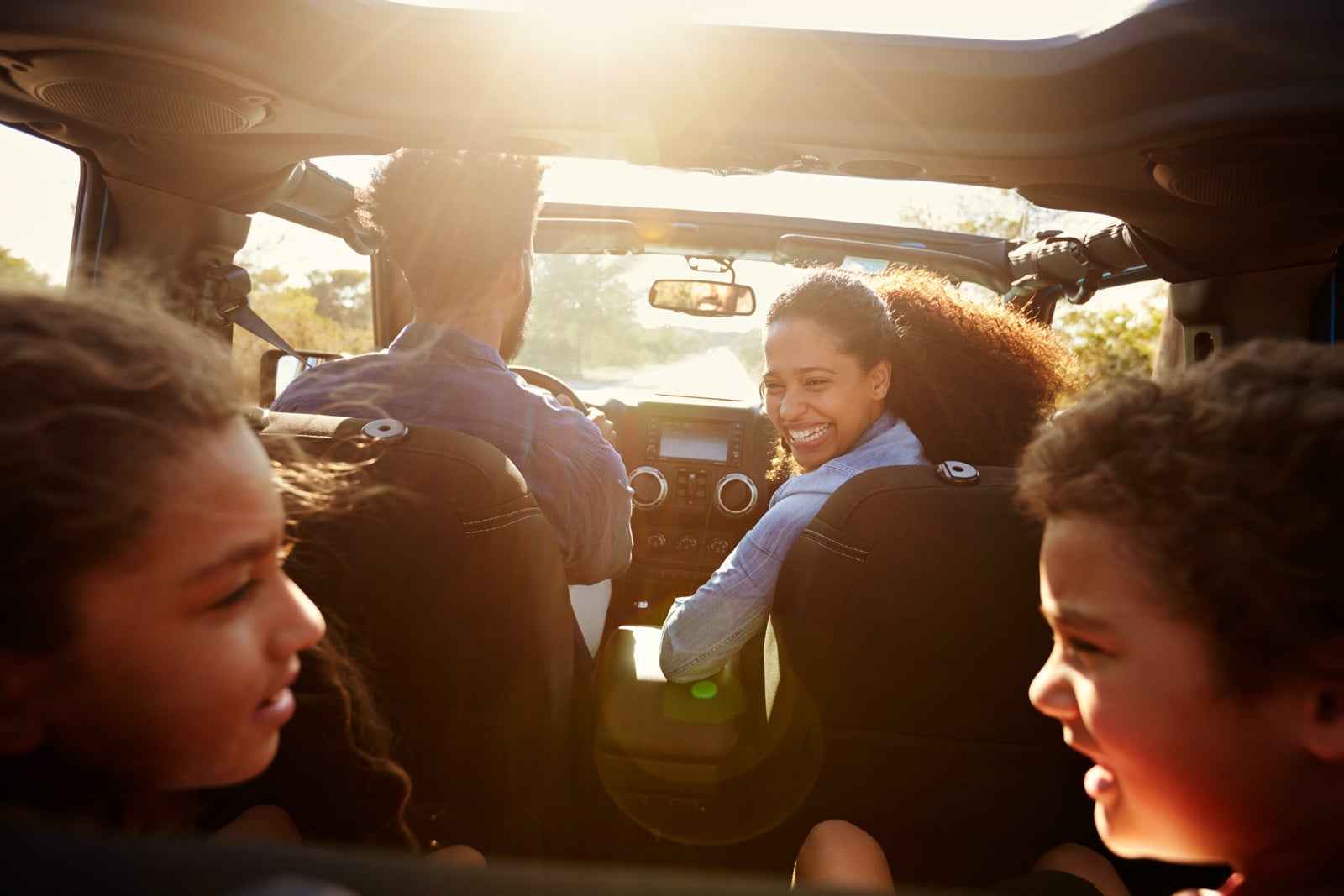 Happy family on a road trip in their car, rear passenger