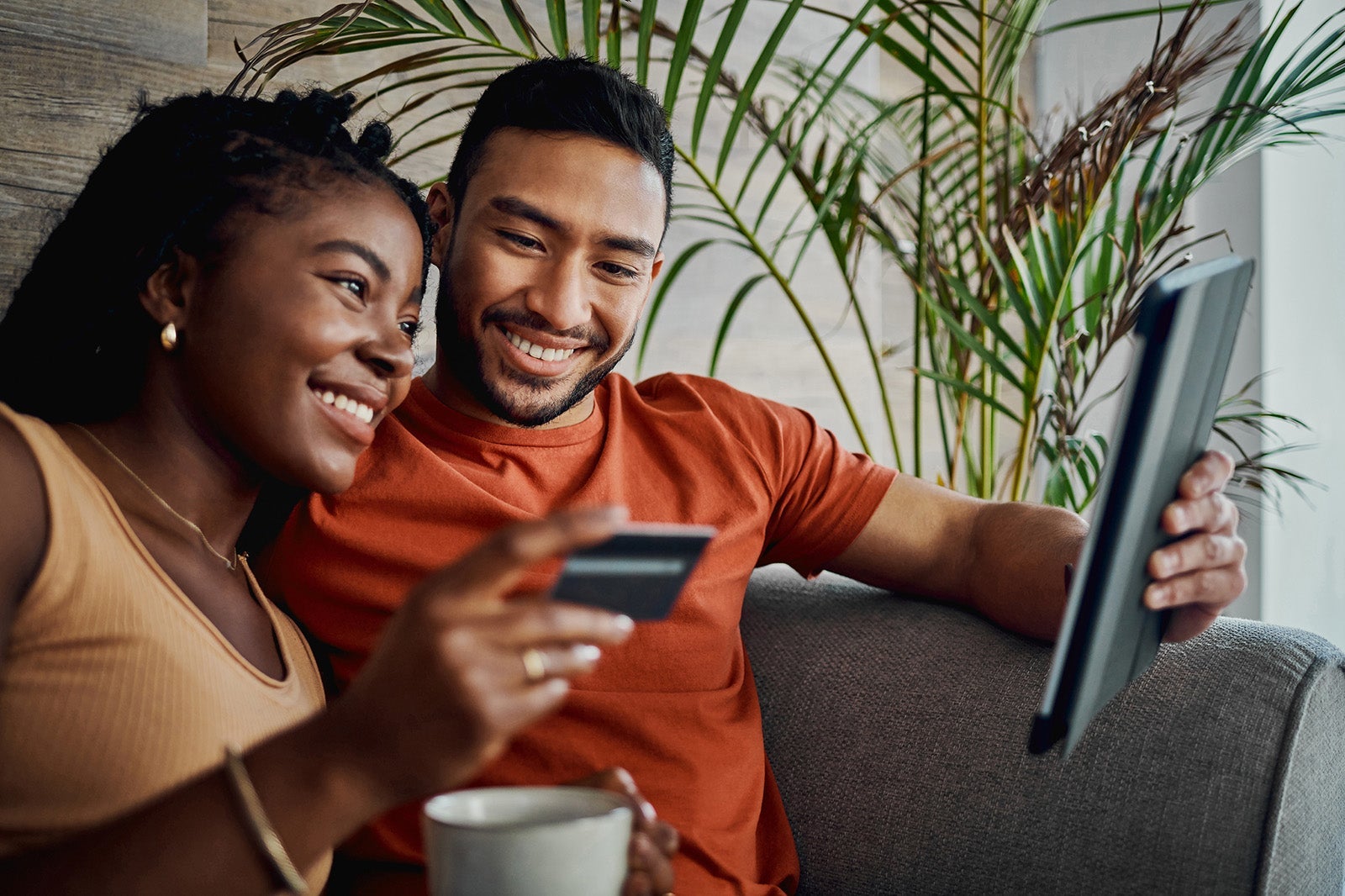 Shot of a young couple sitting together in the living room and using a digital tablet for online shopping