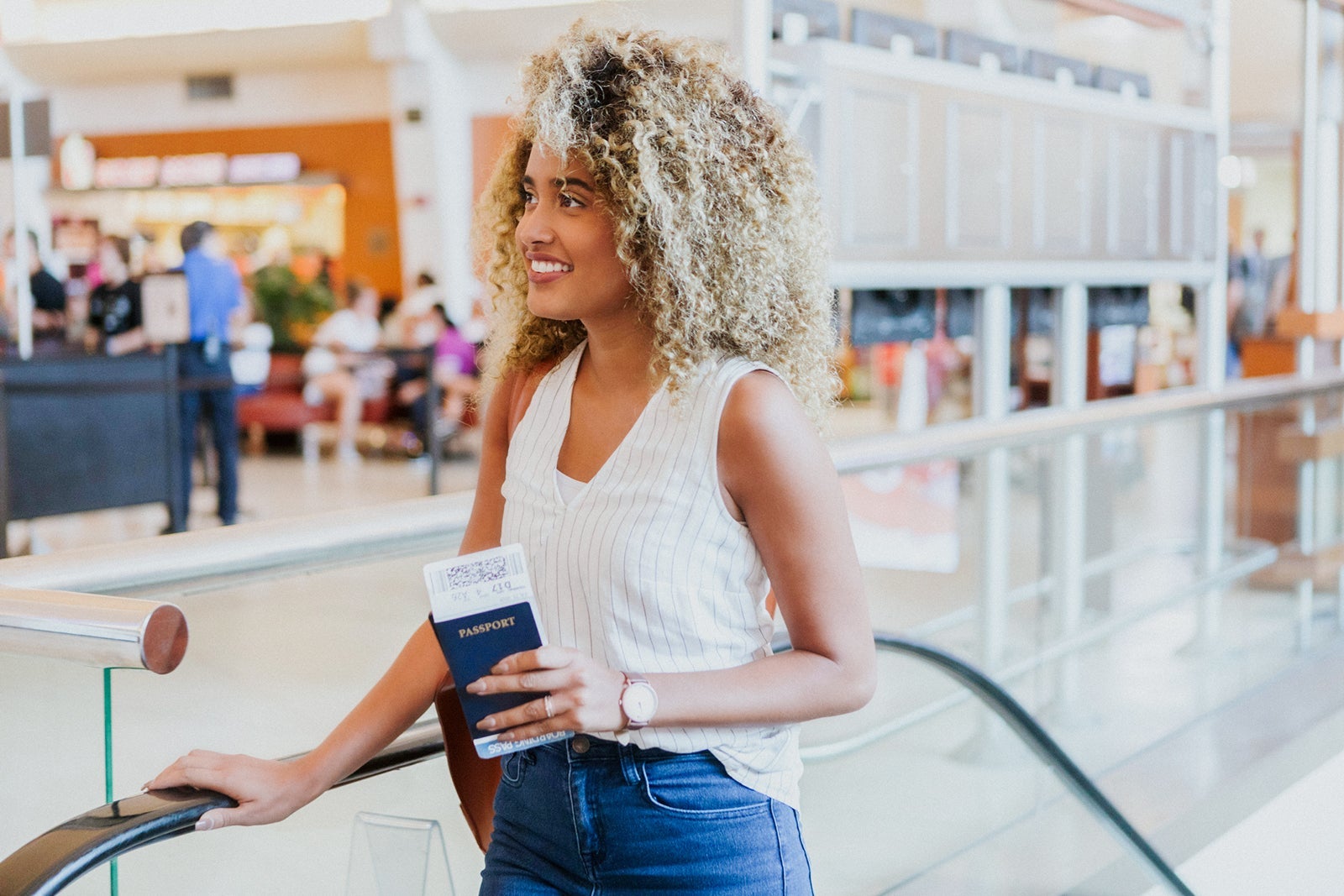Cheerful international traveler ascends airport escalator