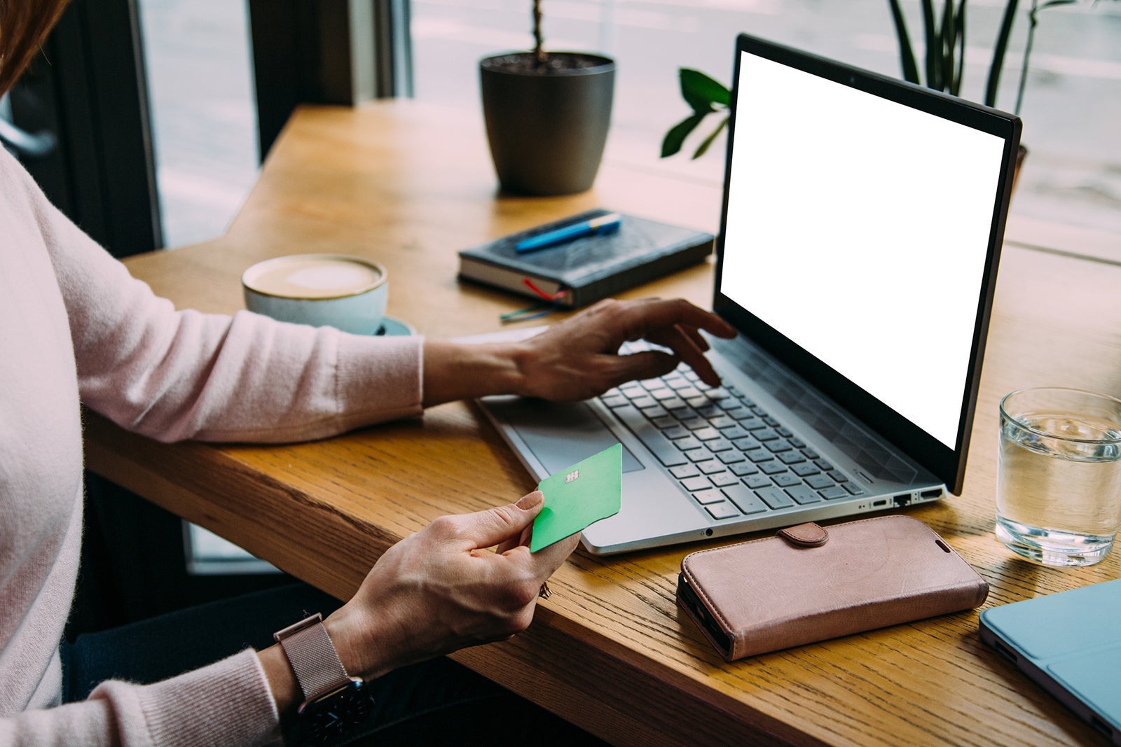 Young woman holding credit card and using laptop