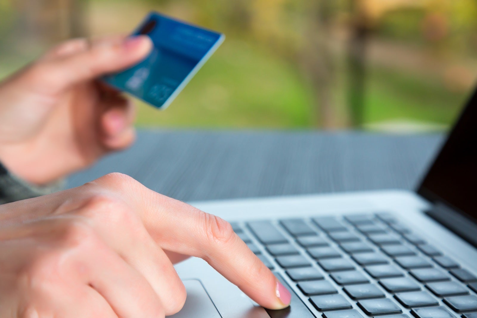 Hands of person entering credit Card Data on Laptop