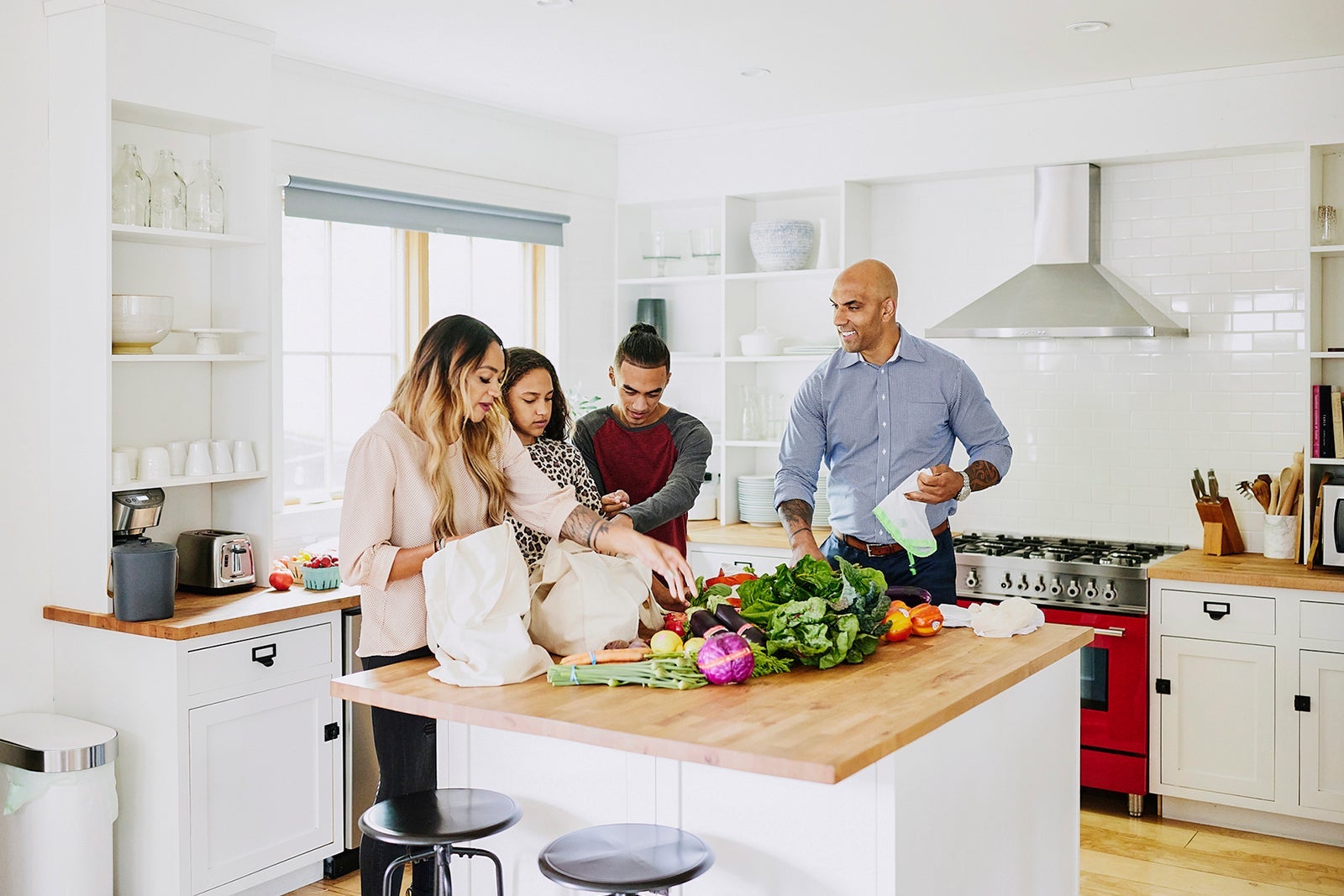 Wide shot of family unloading fresh produce in kitchen after shopping