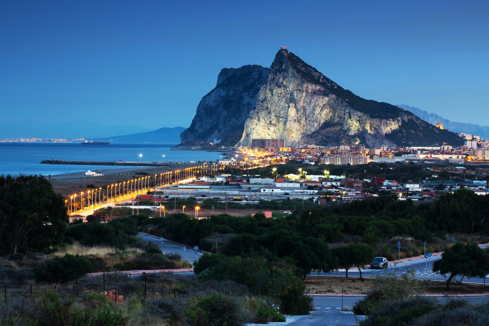 Travel destination: Gibraltar Rock and La Linea de la Conception at blue hour - Morocco (Africa) in the background (Spain and Gibraltar/ UK)