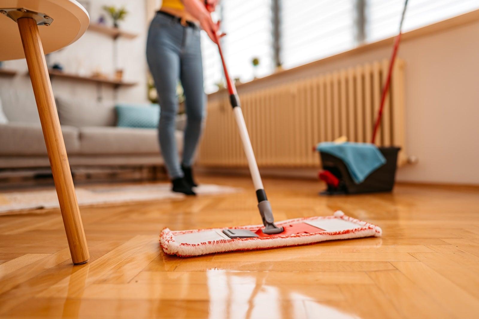 Cleaning parquet floor with wet mop, close up.